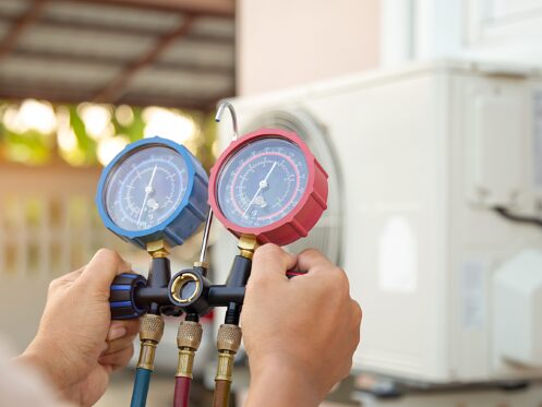 HVAC tech checking refrigerant pressure for leak