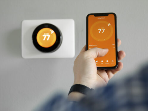 A person adjusting the thermostat using the phone app